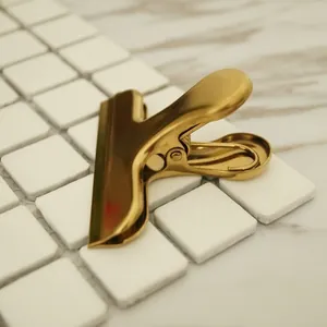Golden stainless steel mountain clip for food sealing and office documents on a desk