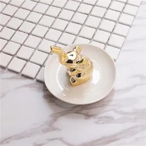 Golden elephant figurine with white ceramic jewelry tray for ring storage and display