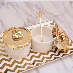 White ceramic honey jar set with gold bee lids and decorative wave tray for jewelry storage