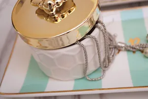 Detailed close-up of honeycomb ceramic storage jar with a polished gold metal lid
