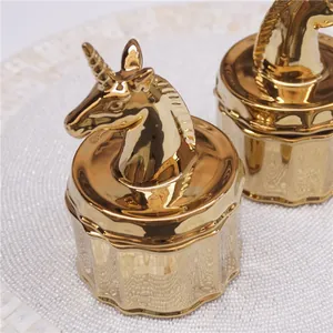 Macro view of gold unicorn and horse head ceramic storage jars with glossy mirror finish