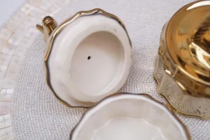 White ceramic jewelry box with golden unicorn lid and scalloped interior edge detail