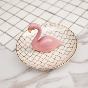 Détail du plateau à bijoux flamant rose avec motifs dorés et finition en céramique