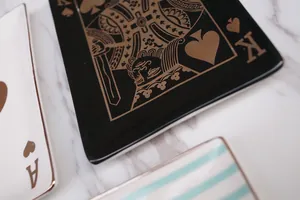 Detailed view of ceramic jewelry tray with gold rim and King of Spades poker card design
