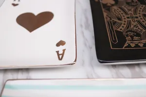 Detailed view of ceramic jewelry tray with gold-rimmed poker Ace of Hearts design