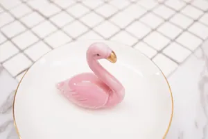 Plateau à bijoux flamant rose en céramique avec détails dorés sur du marbre