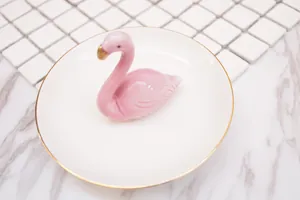 Détail du plateau à bijoux flamant rose en céramique avec bordure dorée élégante