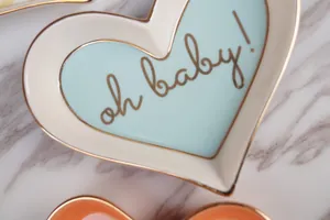 Detail einer herzförmigen Keramik-Schmuckschale mit Goldrand und oh baby Aufschrift