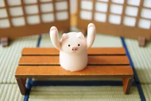 Cute pink pig figurine desk card holder placed on a miniature wooden stool decor