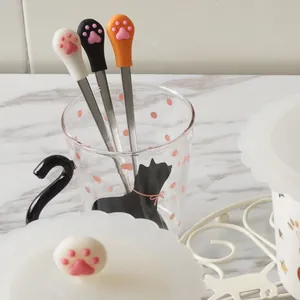 Set of cute cat paw stainless steel coffee spoons with 3D silicone pads on marble desk