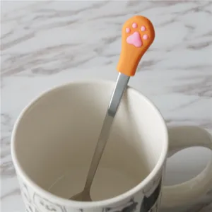 Detail of orange silicone cat paw handle on a polished stainless steel coffee spoon