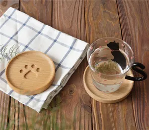 Detailed view of cat paw wooden coaster with cat-themed glass cup on tabletop