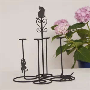 Detail of cute black cat iron wire cup holder with multi-rod stand and spiral stable base