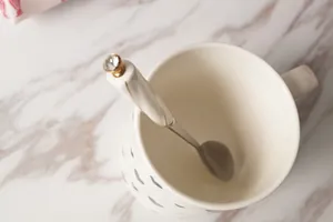 Mug en céramique à motif cœur avec cuillère dorée sur fond de marbre élégant