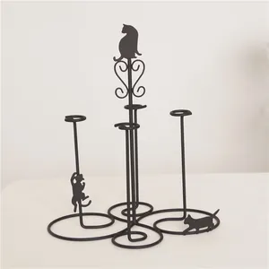 Detail of black iron cat jewelry stand featuring kitten silhouettes and four display tiers