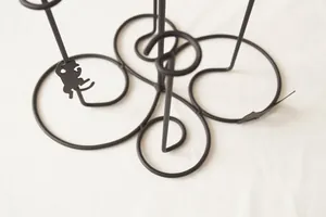 Macro detail of cat silhouette ornaments on a black iron wire kitchen rack base