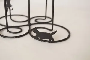 Black cat ironware cup holder with minimalist matte metal design and circular base