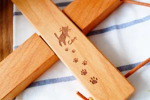 Sottopentola a croce in legno naturale con incisioni di gatti per protezione dal calore