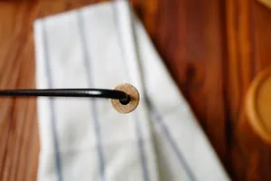 Nahaufnahme eines schwarzen Metall-Handtuchhalters mit Endkappe aus natürlichem Holz