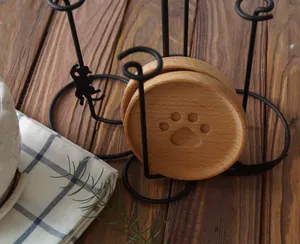 Detailed macro view of wood cat paw coasters stored in a black metal cat silhouette holder