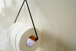 Minimalistischer hölzerner Klopapierhalter zur Wandmontage mit schwarzem Metallrahmen