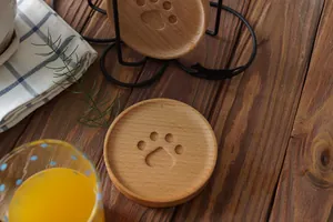 Close-up of cat paw wooden coasters with a black metal holder on a rustic table