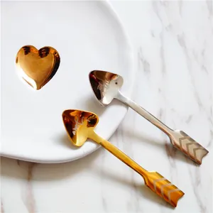 Detalle de cucharas de acero inoxidable en forma de corazón con diseño de flecha y grabado me/you