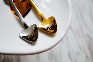 Detalle de cucharas de acero inoxidable con forma de corazón y grabados pulidos Me y You