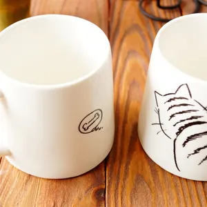 Juego de tazas de cerámica japonesa con diseño de gato sobre una mesa de madera rústica