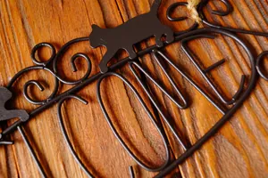 Vintage black wrought iron cat silhouette welcome sign with rustic jute hanging rope