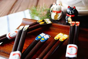 Vue macro de baguettes en bois naturel avec motifs japonais colorés de chat Maneki-neko