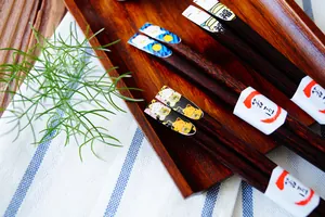 Baguettes japonaises en bois avec motif chat porte-bonheur sur un plateau en bois