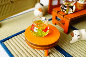 Miniature glass goldfish bowl on wooden table for dollhouse decor with realistic fish
