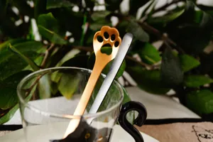 Detail of stainless steel cat paw coffee spoon in a glass with minimalist design