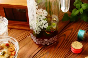 Dettaglio di caraffa e tazze in vetro resistenti al calore con motivi in pizzo bianco