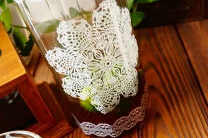 Dettaglio caraffa in vetro vintage con motivo pizzo bianco e testo The Fresh Flower