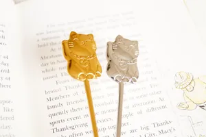 Macro shot of stainless steel lucky cat dessert spoons in gold and silver finish