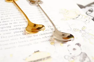 Detailed view of the creative crown-top dessert spoons in polished gold and silver finishes