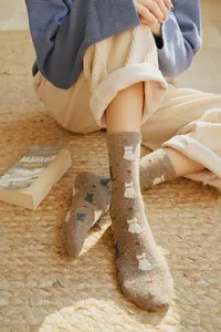Close-up of cozy brown cat silhouette socks with red heart accents in a home setting