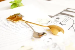Detailed close-up of cat-shaped stainless steel coffee spoons in gold and silver finish