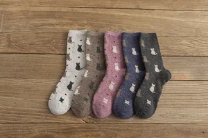 Flat lay of five pairs of vintage Japanese cat socks on a rustic wooden background