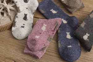 Detailed knit texture of vintage cat patterned crew socks on a rustic wooden surface