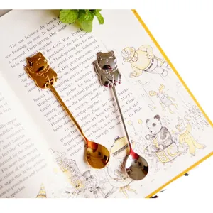Gold and silver 304 stainless steel spoons with cute Lucky Cat handle on a book