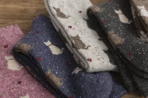 Detailed texture of knitted mid-calf socks with cute cat patterns and heart accents