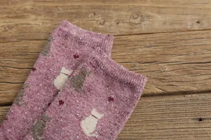 Detailed close-up of retro rose purple knit socks with cute cat patterns and heart accents