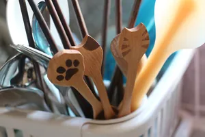 Gros plan d'un manche de cuillère en bois avec motif de patte de chat et grain de bois