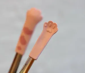 Détail des pinces de cuisine patte de chat avec coussinets en silicone et manche en inox