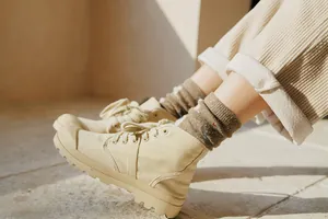 Detail of high-top canvas boots in desert beige with thick anti-slip rubber soles for outdoor wear