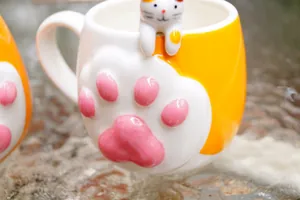 Creative ceramic cat paw mug with 3D pink pads and a cute kitten hanging ornament