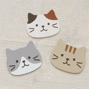 Detailed view of three cute silicone cat-shaped coasters on a lace tablecloth for home